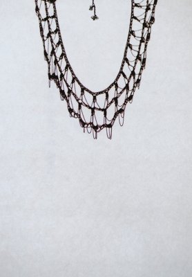Yasuhide Ono “Ripples of Light” 2019 Brass, Double pointed quartz 490×60 Organic, delicate and beautiful necklace like light ripples. A piece of brass chain knitted like lace. Yasuhide Ono combined small sparkling of some double pointed quartz. The same pattern repeated as a plant is like a tribe of ethnicity. A warm and beautiful work that senses changes in hand movement in repeated patterns.